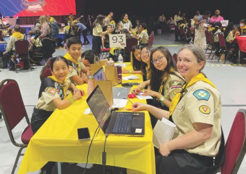 The team smiles for a photo at their competition table.