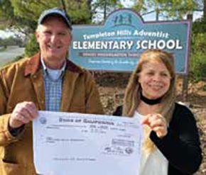 Malon Bruce, board chairperson, and Carmen Collins, principal, display the check received by Templeton Hills Adventist School as a federal assistance grant for private schools.